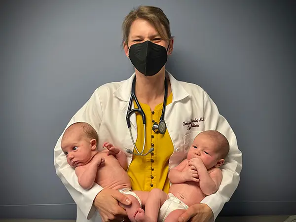 Dr. Bandari holding two infants