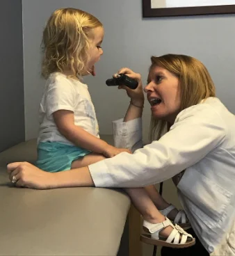 Kate Shand giving a little girl a check-up